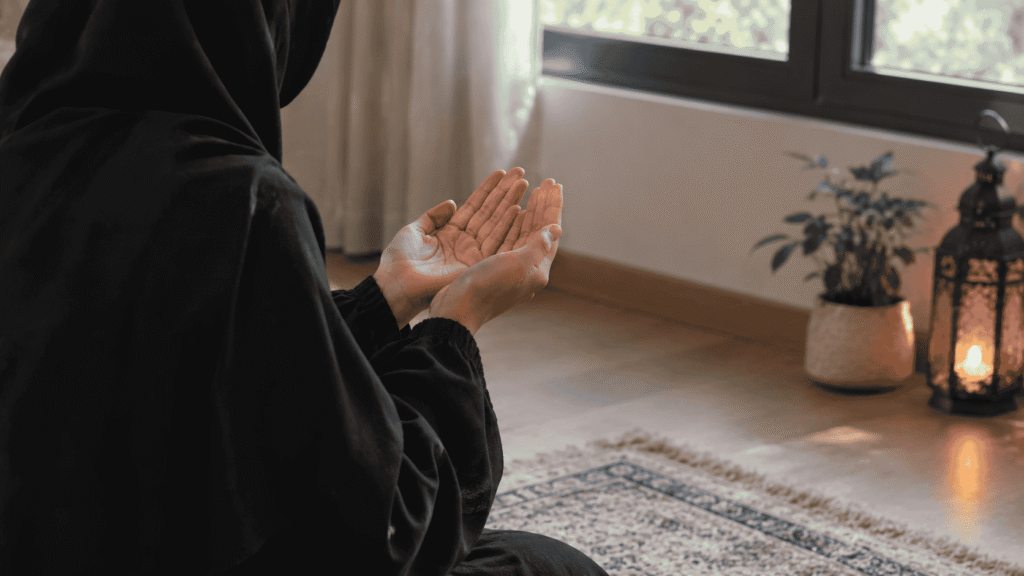 Woman making dua with her face hidden in a peaceful indoor setting
